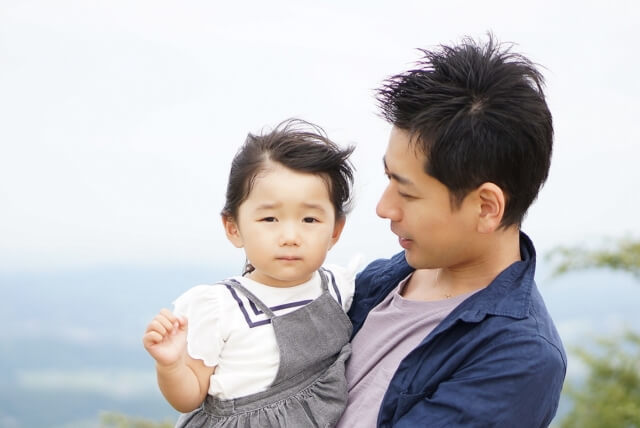 子供を抱いている男性の写真