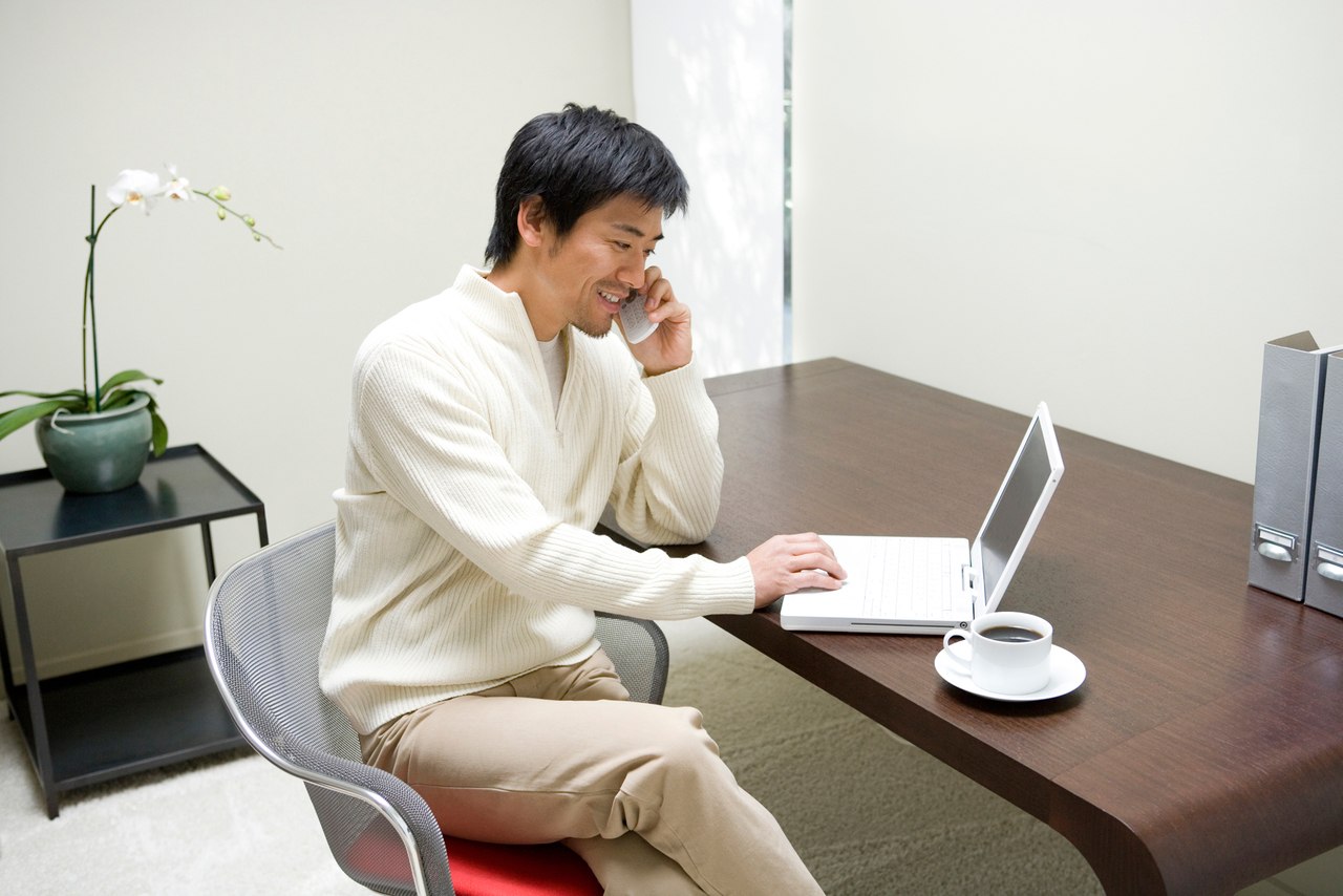 パソコンで消費者金融に申し込みをする男性